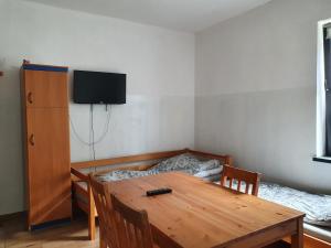 Habitación con mesa, cama y TV. en Wrzosowa 10, en Sosnowiec