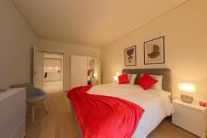 a bedroom with a large white bed with red pillows at Bright and Airy 1-Bedroom Flats in Neuchâtel City Center! RDM2 in Neuchâtel