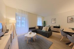a living room with a couch and a table at Bright and Airy 1-Bedroom Flats in Neuchâtel City Center! RDM2 in Neuchâtel