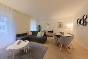 a living room with a couch and a table at Bright and Airy 1-Bedroom Flats in Neuchâtel City Center! RDM2 in Neuchâtel