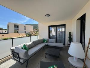 a living room with a couch on a balcony at Appartement dans résidence avec piscine in Calvi