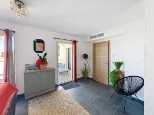 a living room with a table and a chair at Appartement dans résidence avec piscine in Calvi