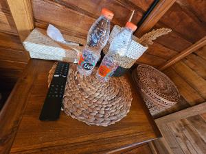a table with two bottles of water and a remote control at Lumbung Hill Glamping in Tabanan