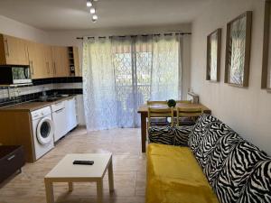 a living room with a couch and a kitchen at Studio piscine parking Cannes in Cannes