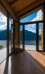 una sala de estar abierta con puertas correderas de cristal en Tra Lago e Montagna Baita la Morena, en Nesso