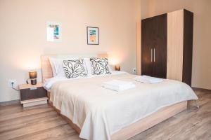 a bedroom with a large bed with two towels on it at Breeze Atelier in Varna City