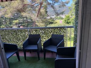 three chairs sitting on a balcony with a view at Studio piscine parking Cannes in Cannes