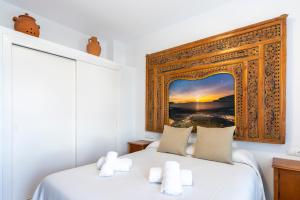 a bedroom with a bed with a picture on the wall at Apartamentos Cel Blau in Es Cana