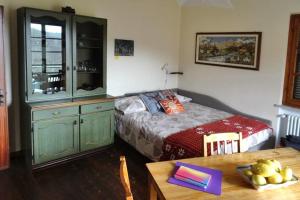 a bedroom with a bed and a dresser and a table at Casa Vacanze Sol&sport in Caprauna