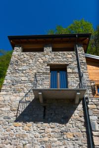 een raam op een stenen gebouw met een balkon bij Tra Lago e Montagna Baita la Morena in Nesso