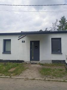 Casa blanca con puerta y ventanas negras en Wrzosowa 10, en Sosnowiec