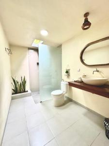 ein Badezimmer mit Toilette, Waschbecken und Spiegel in der Unterkunft The Dulu Penida in Nusa Penida + 44 Fotos