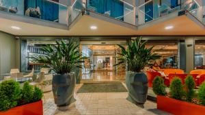 a lobby with two large potted plants at Essence Hotel Boutique in Torremolinos