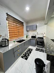 a kitchen with marble counter tops and a window at Hadraj Moshono Apartment2 in Arusha