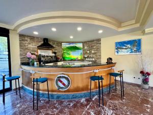 eine große Küche mit einer Bar mit blauen Stühlen in der Unterkunft Hotel Fontalleccio in Procchio