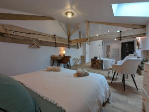a bedroom with a large white bed with two towels on it at Les Pierres Douces in Champniers