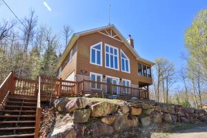 a house on a hill with a stone wall at Chalets Lanaudière in Rawdon