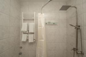 y baño con ducha y toallas blancas. en Dani's House, en Telavi