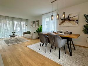 a dining room and living room with a table and chairs at Seeland Bijou Apartment - 2 bedrooms in Kerzers