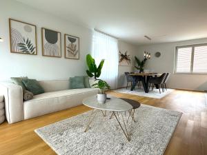 a living room with a couch and a table at Seeland Bijou Apartment - 2 bedrooms in Kerzers