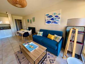 ポルニシェにあるCharmant T2 direct plageの青いソファとテーブルのあるリビングルーム