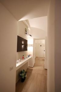 a room with a hallway with white walls and wooden floors at Le chiavi di Parthenope in Naples