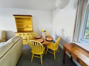 Thistle Cottage في Wootton Bridge: غرفة طعام مع طاولة وكراسي صفراء +21 صورة