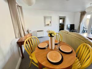 Thistle Cottage في Wootton Bridge: غرفة طعام مع طاولة مع كراسي وأريكة