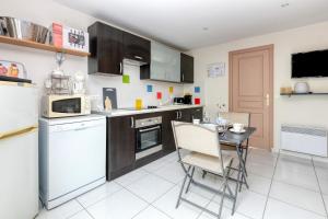 a kitchen with a table and chairs in it at Le Refuge Salin Duplex Jardin in Batz-sur-Mer +12 photos