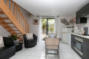 a kitchen and living room with a table and chairs at Le Refuge Salin Duplex Jardin in Batz-sur-Mer
