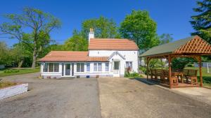 a white house with a gazebo and a bench at SPA Cottage With Mineral Water in Stamford