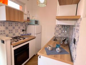 Una pequeña cocina con fregadero y refrigerador. en La Casetta Del Pescatore by Holiday World, en Cogoleto