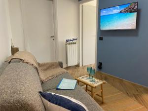 Una sala de estar con un sofá y un televisor de pantalla plana. en La Casetta Del Pescatore by Holiday World, en Cogoleto