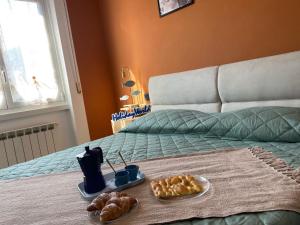 Una cama con dos platos de comida y pan encima. en La Casetta Del Pescatore by Holiday World, en Cogoleto