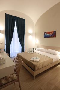 a bedroom with a bed and a table and a window at Le chiavi di Parthenope in Naples
