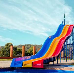 a rainbow colored slide in a playground at Casa Mairinque São Roque Pq Aquático in Mairinque