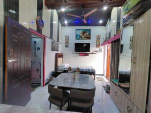 a room with a table and chairs and a tv at Sukoon Villa in Tezpur