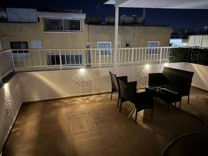 a patio with chairs and a table on a balcony at night at Emerald Luxe in Ayia Napa