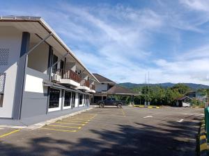 a building with a car parked in a parking lot at Nucifera Hotel Tambunan in Talongan