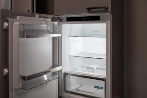 an empty refrigerator with its door open in a kitchen at BetweenLakes Studio ground floor west in Interlaken