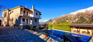 a building with a swimming pool in front of a mountain at Philoxenion Resort Di Montagna in Pramanta