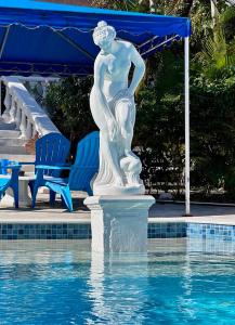 a statue in the water next to a swimming pool at Sun Caraibes in Orient Bay