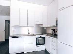 Una cocina blanca con gabinetes blancos y un fregadero. en Levin Kotka 1 & 2 - Twin Units in Heart of Levi, en Levi