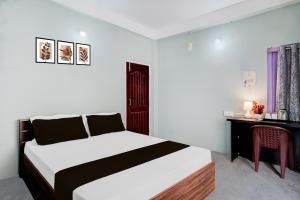 a bedroom with a bed and a desk and a table at Hotel O Sunrise Guest House in Guwahati