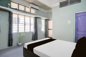 a bedroom with a bed and a purple door at Hotel O Sunrise Guest House in Guwahati