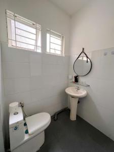 a white bathroom with a toilet and a sink at FlexiHome in Ho Chi Minh City +2 photos