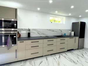 a kitchen with white marble counter tops and a refrigerator at Le Jardin d'Eden by Leslodgespa in Blotzheim