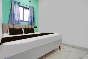 a bedroom with a large bed with blue walls at Hotel O Galaxy Stay in Chandrapur