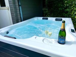 een hot tub met 2 glazen wijn en een fles champagne bij Chalet d'hôtes - Les Daims - Petit déj & Wellness inclus in Fauvillers +14 foto's