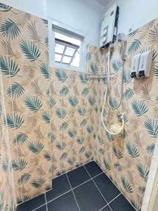 バンコクにあるComfy Crib Hostelのパームレストの壁紙が貼られたシャワー付きのバスルーム